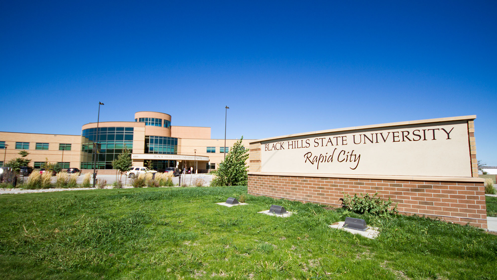 Image of BHSU-RC campus with green grass and sign.